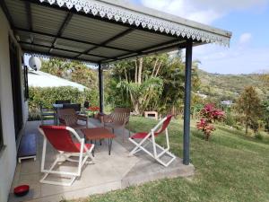 eine Terrasse mit Stühlen und einem Tisch unter Markise in der Unterkunft Mouck's Paradise in Tambe