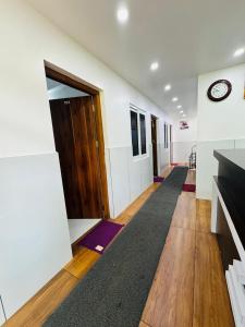 a hallway with a door and a clock on the wall at Barkka in Ponnāni +7 photos