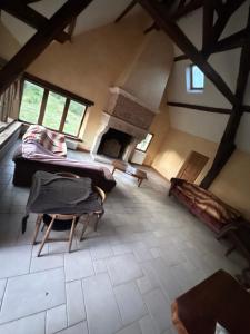 Souesmesにあるmaison campagneのソファと暖炉のある屋根裏部屋