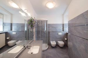 a bathroom with three sinks and three toilets in it at Luxury Lakefront Property in Lezzeno +23 photos