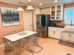 Una cocina con mesa y sillas y un refrigerador. en Modern SD Oasis with Pool & HotTub, en San Diego