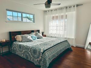 Un dormitorio con una cama y un ventilador de techo. en Modern SD Oasis with Pool & HotTub, en San Diego