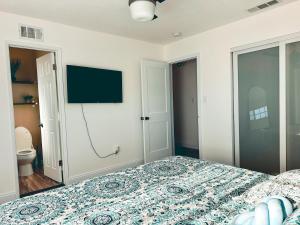 Un dormitorio con una cama y un televisor de pantalla plana. en Modern SD Oasis with Pool & HotTub, en San Diego