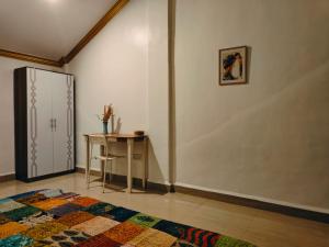 カナコナにあるHome Beach Bunglowsのデスク、冷蔵庫、テーブルが備わる客室です。