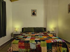 カナコナにあるHome Beach Bunglowsのベッドルーム1室(カラフルなキルトのベッド1台付) +7枚の写真