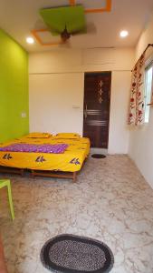 a bedroom with a yellow bed in a room at Shree krishna homestay in Hampi