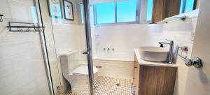a bathroom with a toilet and a sink and a shower at Sweeping Harbour & Ocean Views Over Sydney's East in Sydney