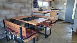 a small kitchen with a wooden table and a sink at Cabañas KIMA I in Huerta Grande