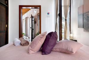 a bedroom with a bed with purple and white pillows at Guenia I in Teguise