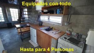 a kitchen with a stove and a stove top oven at Cabañas KIMA I in Huerta Grande