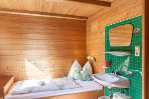 a bathroom with a green tiled wall and a sink at Ferienwohnung Oberangerhof in Kaltenbach +25 photos