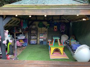 a play tent with a playbench and a table in it at Spacious Cabin with Private Hot Tub, and Private Pool, in 5 Acres - intimate Special stay For 2 Adults - plus 1 child under 2 and up to 2 dogs stay for free in Downham