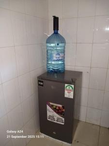 a bottle of water sitting on top of a refrigerator at Mawimbi Pearl staycations in Kilifi