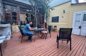 two people sitting at a table on a patio at Escarabajo Hostel in Valparaíso