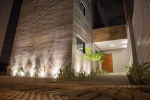 a facade of a building at night with plants at Amenit Hotel in Maceió