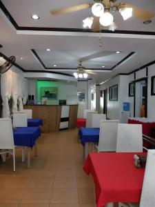 a restaurant with blue and red tables and white chairs at Boracay Breeze Resort in Boracay