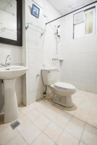 a white bathroom with a toilet and a sink at Boracay Breeze Resort in Boracay +116 photos
