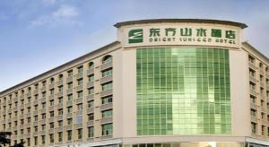 a building with a sign on top of it at Orient Sunseed Hotel Airport Branch in Minzhu