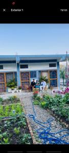 a building with people sitting in front of a garden at two goats fair travel in Rājpur