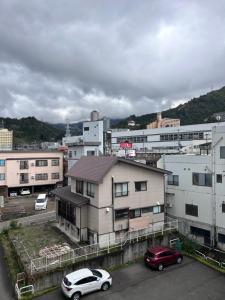 two cars parked in a parking lot in a city at 駅本ビル民宿4階 in Yuzawa