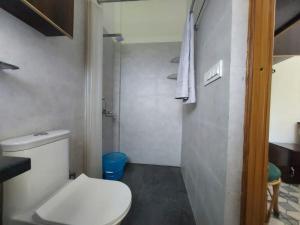 a small bathroom with a toilet and a shower at two goats fair travel in Rājpur