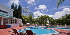 a swimming pool with chairs and a building at Nanhai Oil Hotel in Zhuhai