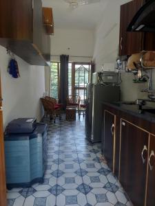 a kitchen with a tiled floor with a refrigerator at two goats fair travel in Rājpur +23 photos