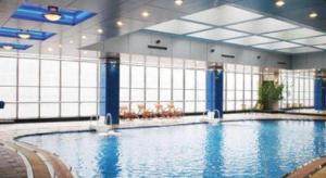a large swimming pool in a large building at Qingdao Haidu Hotel in Huangdao