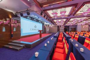 南寧市にあるNanning Qian Xi International Hotelの赤と青の椅子とスクリーンのあるステージ +193枚の写真