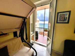 a bedroom with a bed and a view of the ocean at Casa Conchiglia in Vado Ligure