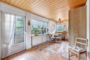 a living room with a wooden ceiling and a table and chairs at Ruhbauernhof in Kirchzarten