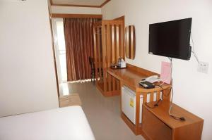 a bedroom with a desk with a television on a wall at Loei Residence in Ban Tha Phae