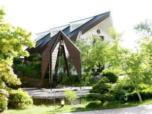 un jardin avec une statue devant un bâtiment dans l'établissement Hotel Royal Hill Fukuchiyama and Spa, à Fukuchiyama