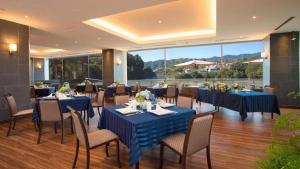 a restaurant with blue tables and chairs and a large window at Takato Sakura Hotel in Ina