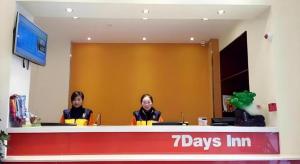 two women sitting at a counter in a days inn at 7 Days Inn Yingshang Lanxing Building Materials Market in Fuyang