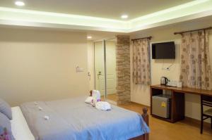 a small child sitting on a bed in a bedroom at The Vintage Residence in Ban Thung Sukla