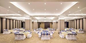 une salle de banquet avec des tables et des chaises dans une pièce dans l'établissement Vienna International Hotel Nanning Railway Station Mingxiu Road Metro Station, à Nanning