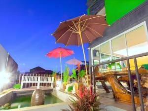 a patio with tables and umbrellas on a building at Tonkok Hotel in Ban Fang Min