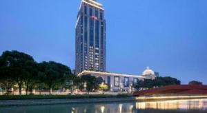 un grand bâtiment en face d'un grand bâtiment dans l'établissement Hampton by Hilton Suzhou XiangCheng, à Suzhou