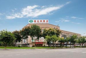 成都市にあるVienna Hotel Chengdu Airport Shuangliu Wandaの上に看板がある建物