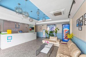 - un salon avec un canapé et un comptoir dans l'établissement Pai Hotel Kunshan Youyi Hospital Qingyang South Road Branch, à Lujiabangzhan