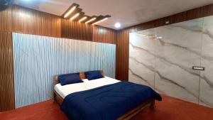 a bedroom with a bed and a marble wall at Kings Court Village Resort in Araku