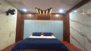 a bedroom with a bed with blue pillows on it at Kings Court Village Resort in Araku +9 photos