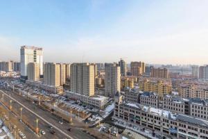 eine Luftansicht einer Stadt mit Gebäuden und Autos in der Unterkunft Jinjiang Inn Select Hohhot Chengjisihan Square Metro Station in Hohhot