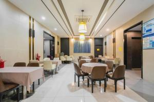 a dining room with white tables and chairs at Magnotel Hotel Shanghai Railway Station Magnolia Plaza in Shanghai