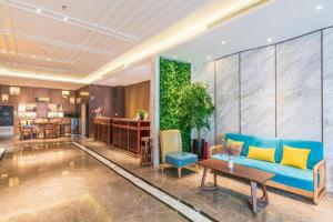 a living room with a blue couch and a table at Jinjiang Metropolo Zhengzhou Songshan Road in Zhengzhou