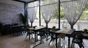 YutianにあるXana Hotelle·Yutianのテーブルと椅子と大きな窓のあるレストラン