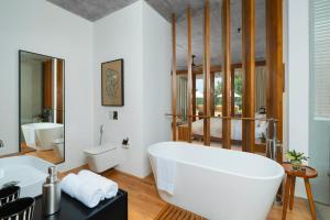 a bathroom with a white tub and a sink at Nyne Hotels Anugrah - Bentota in Bentota +11 photos