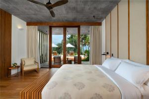 een slaapkamer met een groot bed en een patio bij Nyne Hotels LUXE Anugrah - Bentota in Bentota