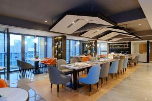 un restaurant avec des tables et des chaises dans un bâtiment dans l'établissement Borrman Hotel Guiyang Guanshanhu International Conference Center Metro Station, à Jinzhuzhen